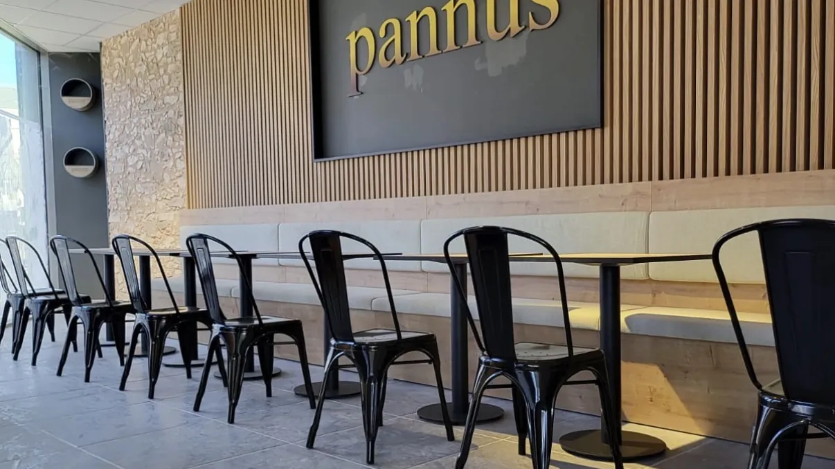 Sala de la panadería-cafetería Pannus con revestimiento de listones de madera y bancada corrida